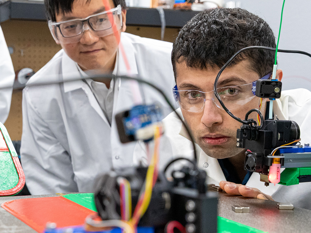 Zhou and one of his students test their 3D printing